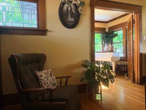 a living room with a chair and a clock on the wall at This Old Frat House Boutique Guest in Missoula