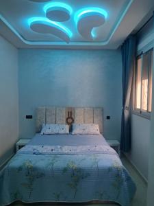 a bedroom with a bed with a blue ceiling at mdiq in M'diq