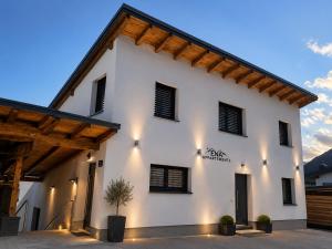 a white building with a wooden roof at Ena Appartements in Altenmarkt im Pongau
