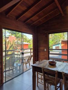 a dining room with a table and chairs on a balcony at Charme e conforto - surf pertinho de casa in Garopaba