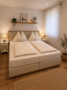 a large white bed in a bedroom with two tables at Ena Appartements in Altenmarkt im Pongau