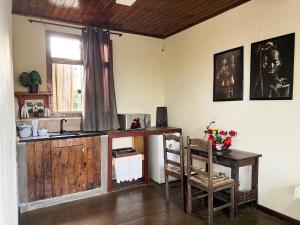 a kitchen with a sink and a table and a window at Chalés do Chá in Lavras Novas +10 photos