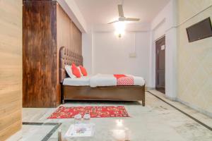 a bedroom with a bed and a red rug at Hotel O Kamini in Patna