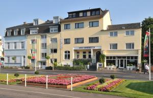 a building with flowers in front of a street at Hotel Ahrbella in Bad Neuenahr-Ahrweiler