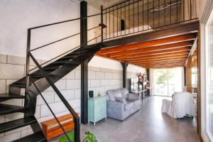 a living room with a spiral staircase in a house at El Pajar - Apartamento rural en la Vía Verde in Luque +22 photos