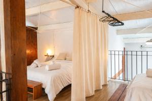a bedroom with two beds and a balcony at El Pajar - Apartamento rural en la Vía Verde in Luque