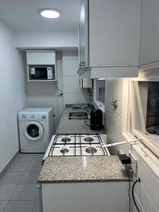 a kitchen with a stove and a washing machine at Torre Parque Apartamento in Morón