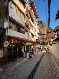 a cobblestone street with a building on a mountain at Apachetas Hotel in Machu Picchu