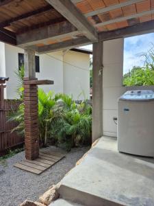 a pergola with a washing machine in a yard at Charme e conforto - surf pertinho de casa in Garopaba