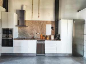 a kitchen with white cabinets and stainless steel appliances at El Pajar - Apartamento rural en la Vía Verde in Luque