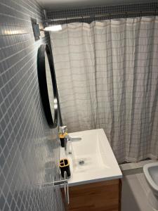 a bathroom with a sink and a mirror at Torre Parque Apartamento in Morón +13 photos