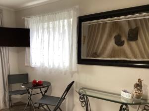 a dining room with a table and a window at Driftwood Sands Studio in Tairua