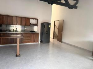 a kitchen with a refrigerator and wooden cabinets at Hotel Barajas in Jardin
