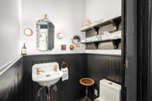 a black and white bathroom with a sink and a toilet at Saint Helens House-Hotel Historic District Near Cruise Port in Galveston +95 photos