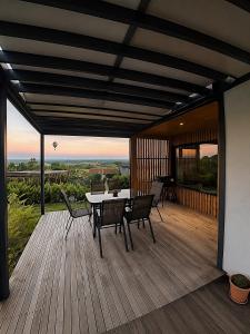 a patio with a table and chairs on a wooden deck at Panorama House in Bartolovci