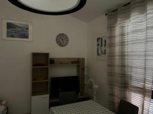 a bedroom with a bed and a clock on the wall at Villa Clelia in Stintino