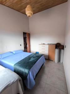 a bedroom with a bed and a dresser in it at Chácara Sol e Lua dos três Morros in Piatã