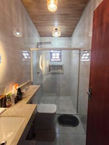 a bathroom with a shower and a toilet and a sink at Chácara Sol e Lua dos três Morros in Piatã +11 photos