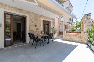 a patio with a table and chairs and a building at Afytos Rooms in Afitos