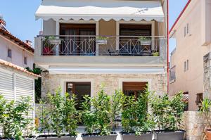 a building with a balcony with plants in front of it at Afytos Rooms in Afitos
