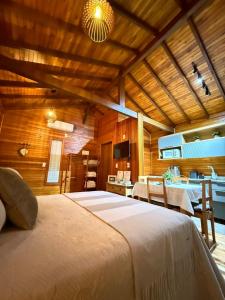 a bedroom with a large bed in a wooden room at Sítio Brisa da Serra Conforto e Tranquilidade in Lauro Müller