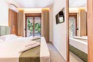a bedroom with two beds and a tv on the wall at Afytos Rooms in Afitos +19 photos