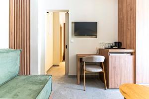 a room with a desk with a chair and a television at Afytos Rooms in Afitos