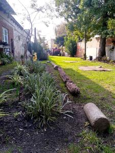 a house yard with a landscaped yard with plants and a log at La Ricarda in Gualeguaychú