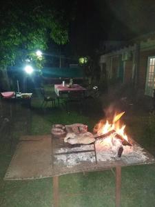 a fire in a yard at night with a picnic table at La Ricarda in Gualeguaychú