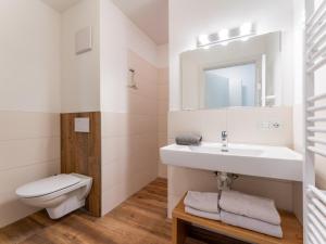 a white bathroom with a sink and a toilet at Bergblick in Werfenweng +44 photos