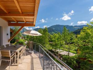 a balcony with a table and chairs and mountains at Werfenblick und Bergblick in Werfenweng