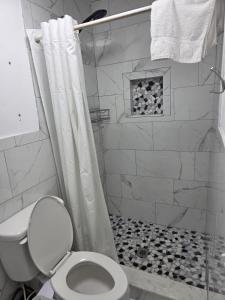 a white bathroom with a shower with a toilet at Lee motel in Nashville