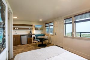 a room with a bed and a kitchen with a table at Manzanita Oceanfront Inn in Manzanita