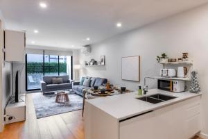 a kitchen and living room with a couch and a table at Bentleigh & Beyond Your Melbourne Getaway in Melbourne