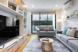 a living room with a couch and a tv at Bentleigh & Beyond Your Melbourne Getaway in Melbourne