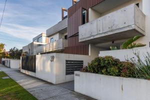 a modern house with white walls and a sidewalk at Bentleigh & Beyond Your Melbourne Getaway in Melbourne