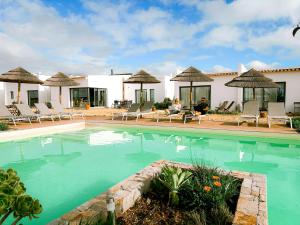a swimming pool with chairs and a house at Agroturismo Xistos in Cerca