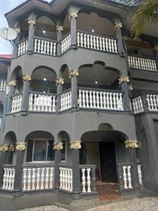 a large white building with a balcony at Rashlie apartment in Freetown