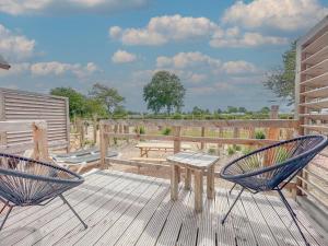 two chairs and a table on a wooden deck at Yellow Bird in Ellemeet