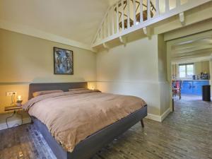 a bedroom with a large bed and a staircase at De Muldershof in Vriezenveen