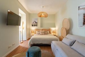 a bedroom with a bed and a couch at Flores 21 Apartments Príncipe Real in Bicas +104 photos