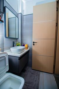 a bathroom with a sink and a toilet and a door at Beryl's Haven in Marimbeti