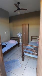 a bedroom with two beds and a ceiling fan at Hotel Reflexos in Santa Juliana