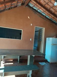 a large table in a room with a refrigerator at Hotel Reflexos in Santa Juliana