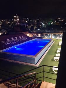 a swimming pool on the roof of a building at night at Hotel Bouery in An Nā‘ūrah