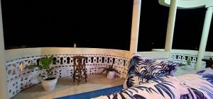 a balcony with a couch and a railing at Charlie's Place Watamu in Watamu