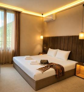 a bedroom with a large white bed in a room at Вила АРБОРЕТУМ in Teteven