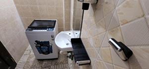 a bathroom with a sink and a soap dispenser at Charlie's Place Watamu in Watamu +38 photos