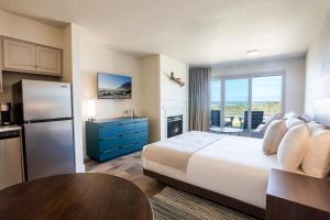 a hotel room with a large bed and a kitchen at Manzanita Oceanfront Inn in Manzanita