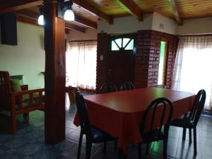 a dining room with a wooden table and chairs at La cabaña de ines in El Bolsón